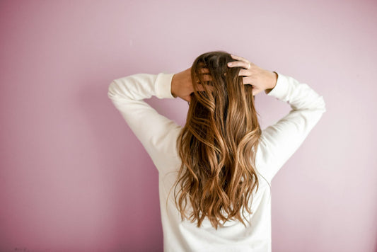 Mujer sosteniendo su cabello largo y saludable con ambas manos